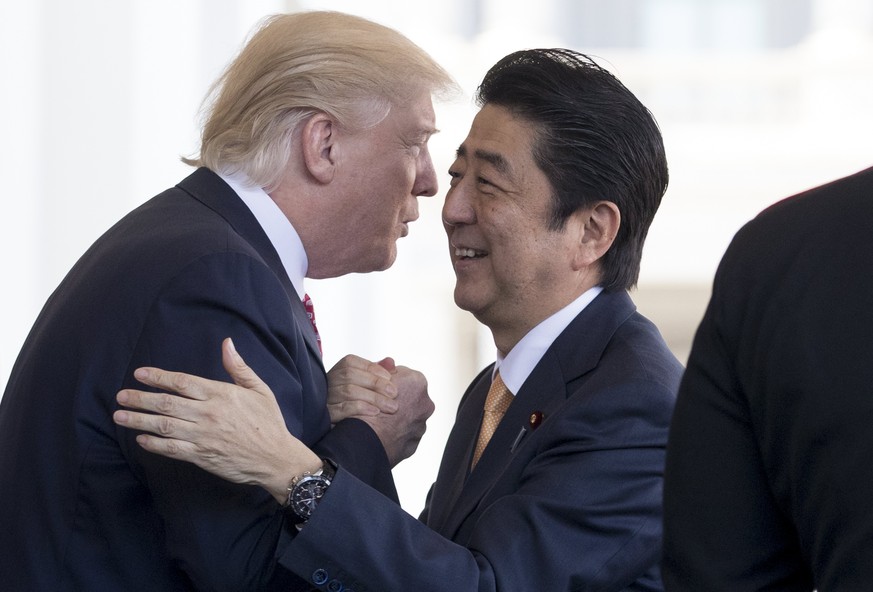 epaselect epa05783435 US President Donald J. Trump (L) greets Japanese Prime Minister Shinzo Abe (R) at the entrance to the West Wing before their meeting in the Oval Office of the White House in Wash ...