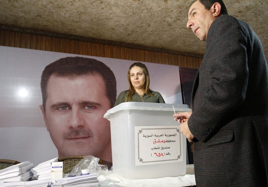 Ein Beamter versiegelt eine Wahlurne in Damaskus.