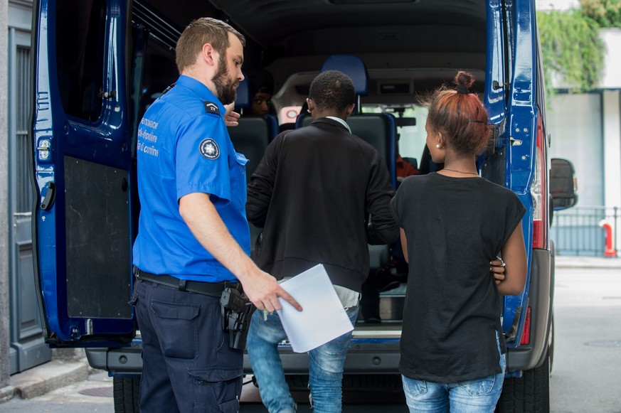 Ein Grenzwaechter begleitet Fluechtlinge, am Dienstag, 12. Juli 2016, auf dem Bahnhof in Chiasso. Die Fluechtlinge wollten mit einem Bus nach Deutschland gelangen, konnten aber an der Schweizer Grenze ...