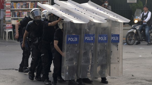 Riot police take cover behind shields as they clash with protesters during a demonstration blaming the ruling AK Party (AKP) government for the mining disaster in western Turkey, in Ankara May 14, 201 ...