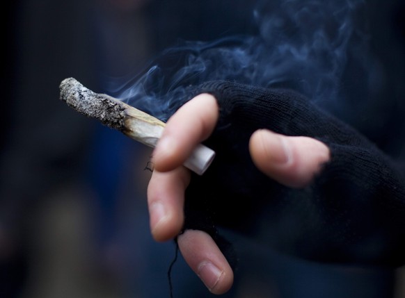 A young man smokes a marijuana joint at the Vancouver Art Gallery during the annual 4/20 day, which promotes the use of marijuana, in Vancouver, British Columbia in this file photo taken April 20, 201 ...