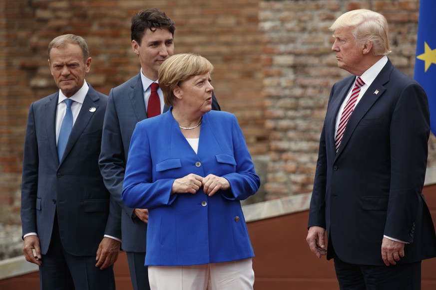German Chancellor Angela Merkel talks with President Donald Trump during a family photo with G7 leaders at the Ancient Greek Theater of Taormina, during the G7 Summit, Friday, May 26, 2017, in Taormin ...