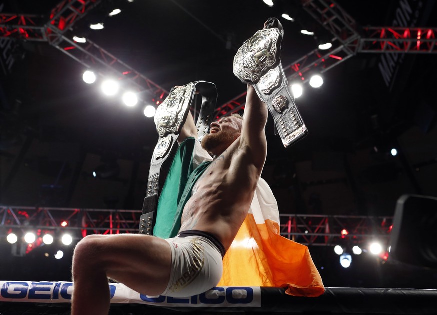 Nov 12, 2016; New York, NY, USA; Conor McGregor (blue gloves) celebrates with his two championship belts after defeating Eddie Alvarez (red gloves) in their lightweight title bout during UFC 205 at Ma ...