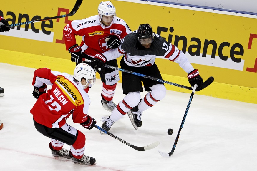 Switzerland&#039;s players forward Denis Malgin, left, and defender Christian Marti, center, vies for the puck with Canada&#039;s forward Wayne Simmonds, right, during a friendly international ice hoc ...
