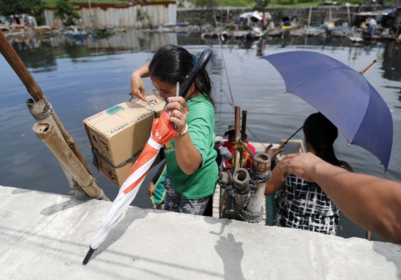 epa07013725 Filipino residents disembark from a makeshift raft ahead of an impending super typhoon in Paranaque city, south of Manila, Philippines, 12 September 2018. According to data supplied by the ...