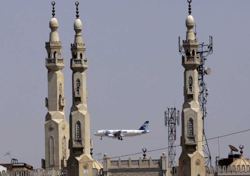 FILE - In this May 21, 2016, file photo, an EgyptAir plane flies past minarets of a mosque as it approaches Cairo International Airport, in Cairo, Egypt. A new U.S. security measure targeting flights  ...