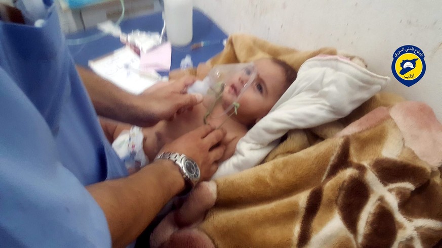 epa05451968 A handout picture made available by the Syria Civil Defense Idlib branch shows a rescue worker giving treatment to a baby who was allegedly affected by a chlorine gas canister attack dropp ...