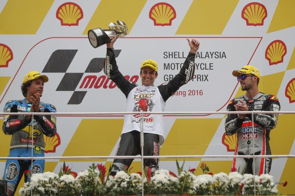 Moto2 winner Johann Zarco of France, center, celebrates with a trophy as second-placed Franco Morbidelli of Italy, left, and third-placed Jonas Folger of Germany applaud during the award ceremony for  ...