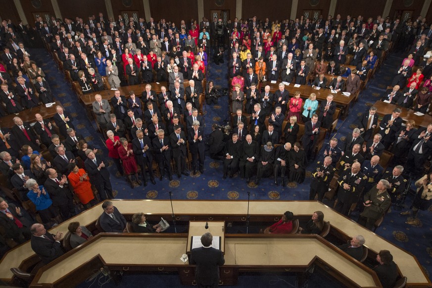 epa04046262 US President Barack Obama (C) receives a standing ovation while delivering his State of the Union address before a joint session of Congress, on Capitol Hill in Washington DC, USA, 28 Janu ...