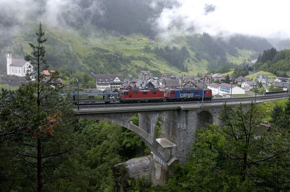 Zwei Rangierloks fahren auf der Gotthardstrecke der SBB in Richtung Erstfeld talwaerts vor dem Kirchlein von Wassen am Samstag, 2. Juni 2007. (KEYSTONE/ Sigi Tischler)