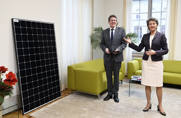 Die zurueckgetretene Bundesraetin Simonetta Sommaruga, rechts, schenkt ihrem Nachfolger im UVEK, Bundesrat Albert Roesti, ein Solarmodul, anlaesslich der Schluesseluebgabe im UVEK, am Freitag, 23. Dez ...