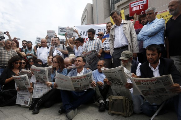 epa06114434 People reads Cumhuriyet newspaper during a rally in front of the Istanbul Courthouse in Istanbul, Turkey, 28 July 2017. Turkish police detained the editor-in-chief Murat Sabuncu, columnist ...