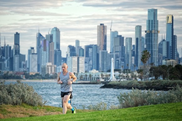 epaselect epa09414590 A man jogs along a pathway at St Kilda in Melbourne, Australia, 15 August 2021. Melbourne&#039;s lockdown has been extended to at least 19 August to contain a growing outbreak of ...