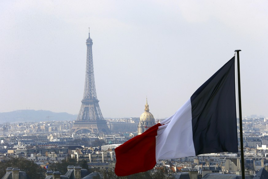 file - In this April 1, 2016 file photo, the French flag above the skyline of the French capital with the Eiffel Tower, The Invalides Dome and roof tops are seen from the colonnade of the Pantheon Dom ...