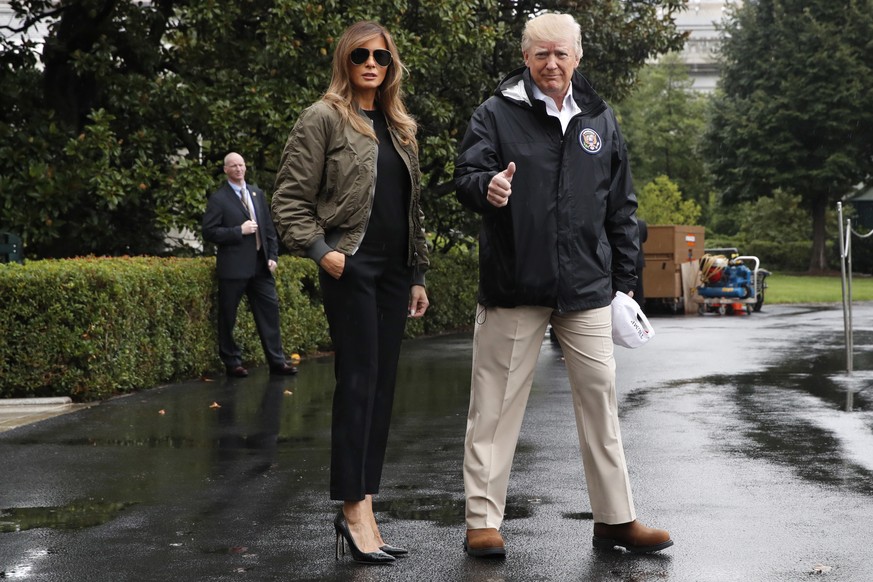 President Donald Trump, accompanied by first lady Melania Trump, gives a thumbs-up as they walk to Marine One on the South Lawn of the White House in Washington, Tuesday, Aug. 29, 2017, for a short tr ...