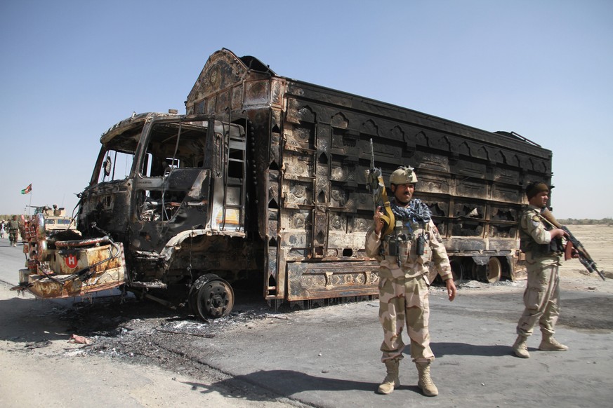 Afghanische Soldaten vor einem ausgebrannten Lastwagen in Ghazni.&nbsp;