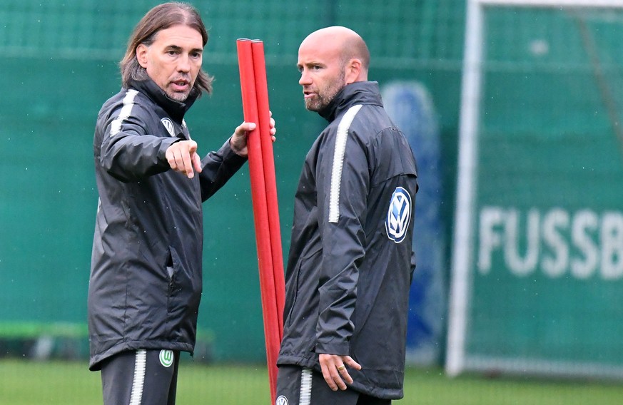 Fussball Bundesliga: Wolfsburgs neuer Trainer Martin Schmidt (l) spricht am 18.09.2017 auf dem Trainingsgelaende der Volkswagen-Arena in Wolfsburg (Niedersachsen) mit seinem Assistenztrainer Stefan Sa ...