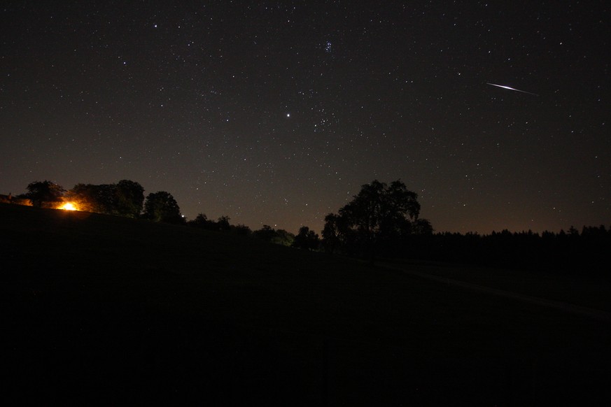 Dicht über dem östlichen Horizont hinweg zischt hier ein Perseiden-Meteor über den Eschenberg.