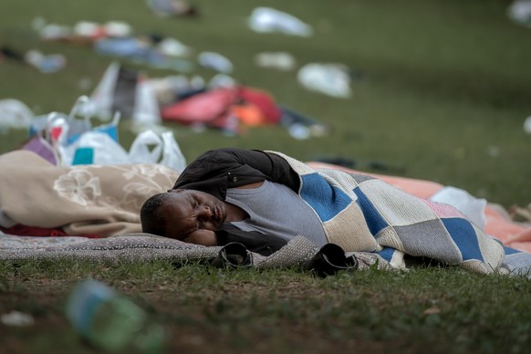 Ein Fluechtling schlaeft auf dem Boden, er gehoert zu einer Gruppe von Fluechtlingen die sich in einem Park wenige hundert Meter vom Bahnhof Como in Italien niedergelassen haben am Freitag, 22. Juni 2 ...