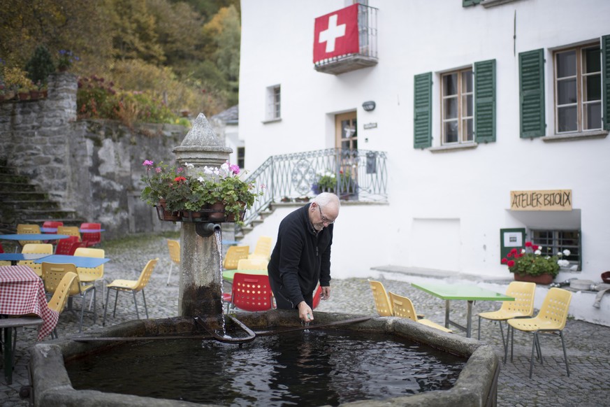 Wirt Donato Salis putzt Tische mit einem Lappen, am Samstag, 14. Oktober 2017, in Bondo. Am 23. August war ein Bergsturz am Piz Cengalo mit Murgaengen nach Bondo niedergegangen. Acht Wanderer gelten s ...