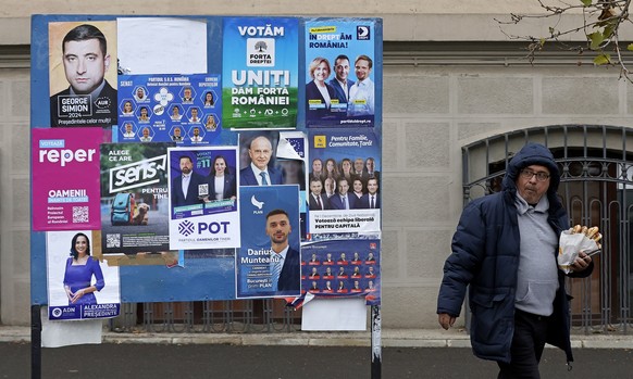 Nachrichten Linkding epa11745509 A man walks past a billboard filled with election posters for the parliamentary elections in Bucharest, Romania, 28 November 2024. The parliamentary elections will be held on 01 December 2 ...