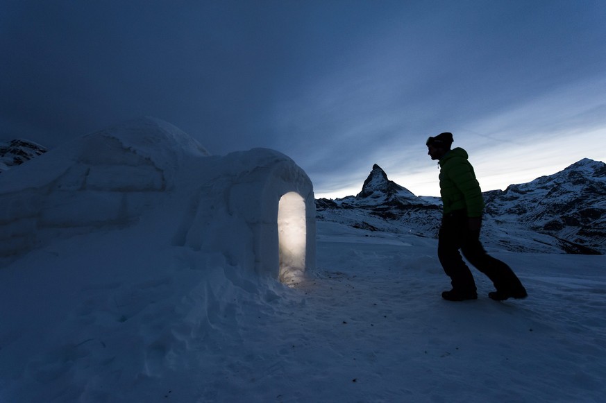 epa05132803 A man enters in a Igloo at the &#039;Igloo village&#039; (Iglu Dorf) in front of the famous Matterhorn mountain in Zermatt, Switzerland, early 29 January 2016. The hotel-igloo village made ...