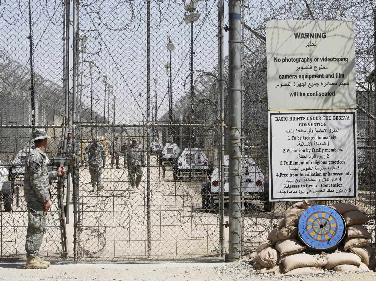 US-Militärangehörige im Camp Bucca – rechts auf einem Schild Grundrechte der Genfer Konvention zur Behandlung von Kriegsgefangenen.