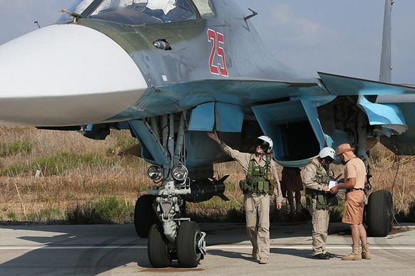 Der Pilot checkt seine mit Bomben beladene Su-34 vor dem Start.