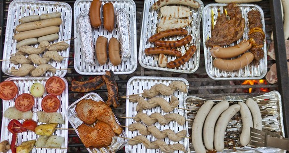 Friends are meeting for a cosy barbecue in a community center in Zurich, Switzerland, on May 25, 2011. They gather around an open fire pit in the garden.The sausages and the barbecue meat laying on th ...