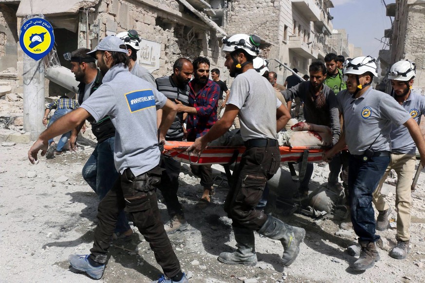 FILE - In this Wednesday, Sept. 21, 2016, file photo, provided by the Syrian Civil Defense White Helmets, rescue workers work the site of airstrikes in the al-Sakhour neighborhood of the rebel-held pa ...