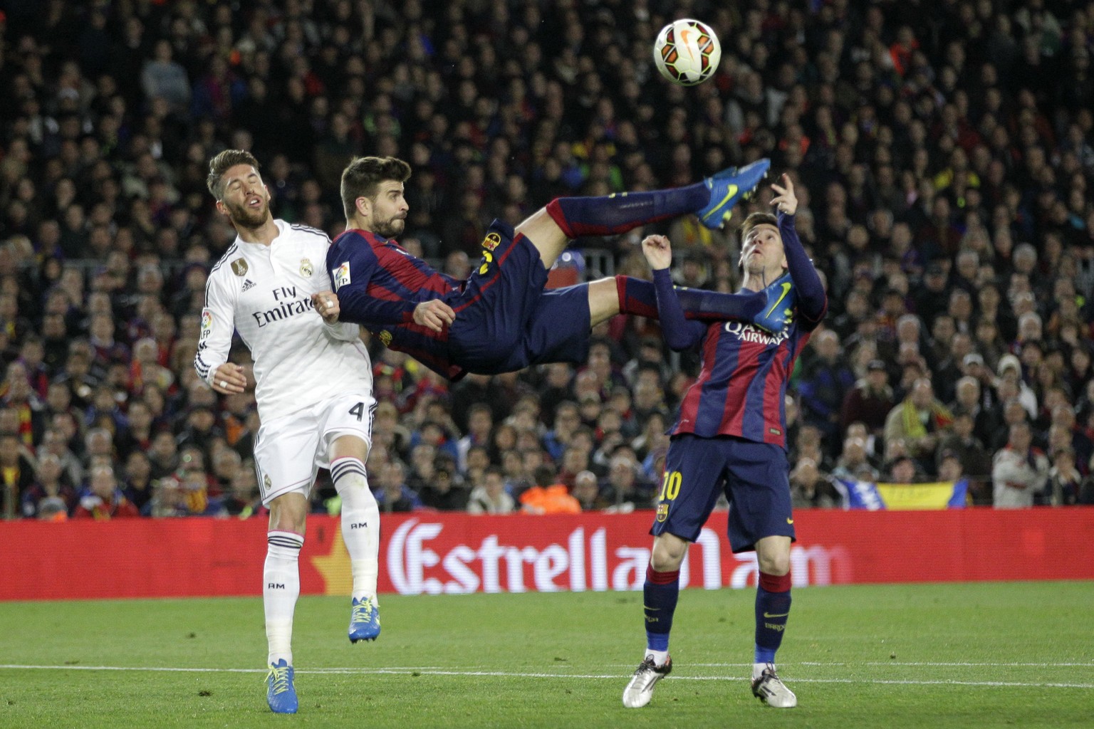 FILE- In this Sunday, March 22, 2015 file photo, Barcelona&#039;s Gerard Pique kicks the ball with Real Madrid&#039;s Sergio Ramos, left, and Barcelona&#039;s Lionel Messi, right, during a Spanish La  ...