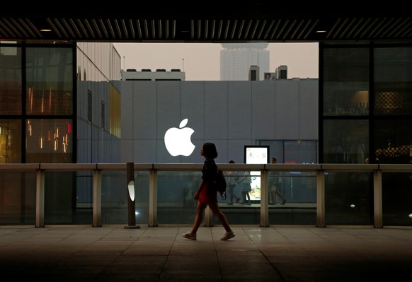 A woman walks past an Apple store in Beijing, China July 28, 2016. REUTERS/Thomas Peter