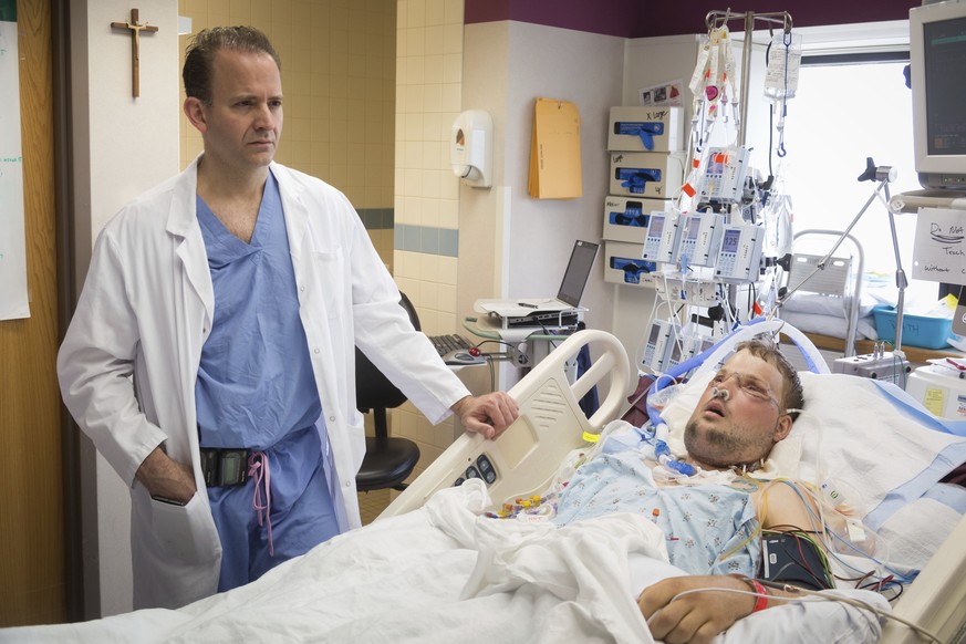 In this June 18, 2016 photo provided by the Mayo Clinic, Dr. Samir Mardini checks on his patient, Andy Sandness, days after leading a team that performed the first face transplant surgery at the medic ...