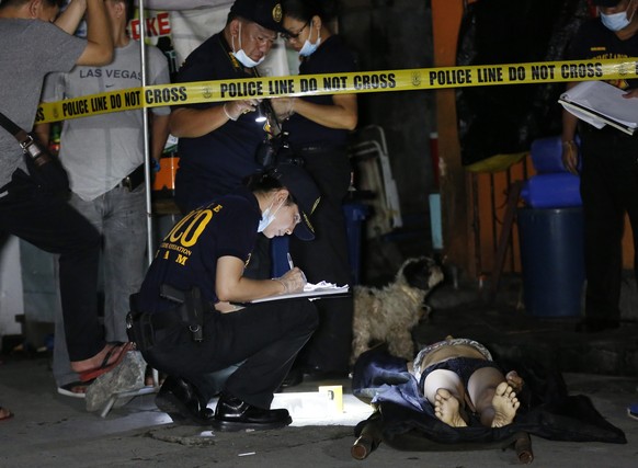 epa05503318 A picture made available on 21 August 2016 shows crime scene investigators inspecting the body of a suspected drug dealer, who was shot dead during a police operation against illegal drugs ...