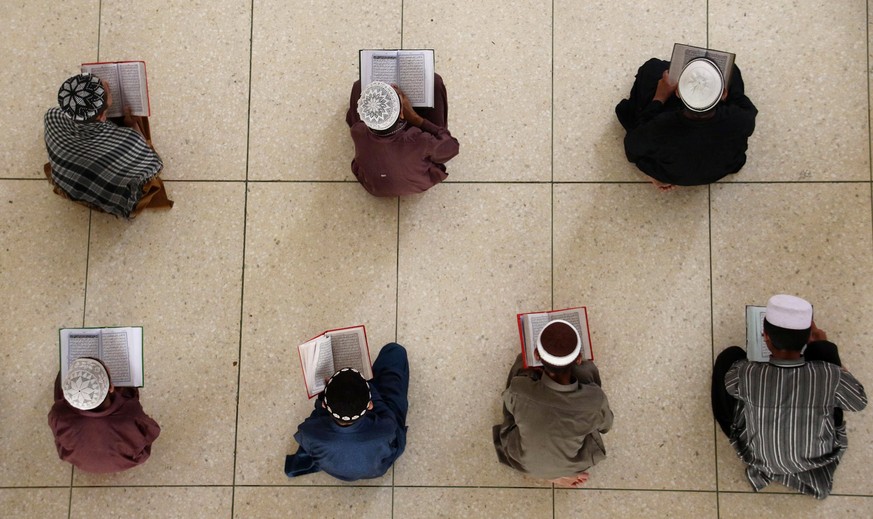 epa06011806 Pakistani Muslims read holy Koran during the holy fasting month of Ramadan, in Karachi, Pakistan, 05 June 2017. Muslims around the world celebrate the holy month of Ramadan by praying duri ...