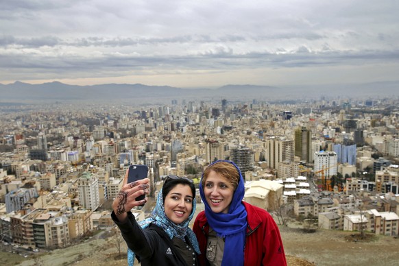 Women take selfies outdoors to observe the ancient festival of Sizdeh Bedar, an annual public picnic day on the 13th day of the Iranian new year, at the Tochal mountainous area northern Tehran, Iran,  ...