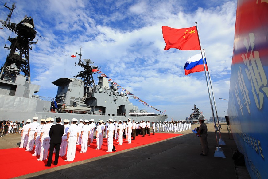 In this photo released by China&#039;s Xinhua News Agency, officers and soldiers of China&#039;s People&#039;s Liberation Army (PLA) Navy hold a welcome ceremony as a Russian naval ship arrives in por ...