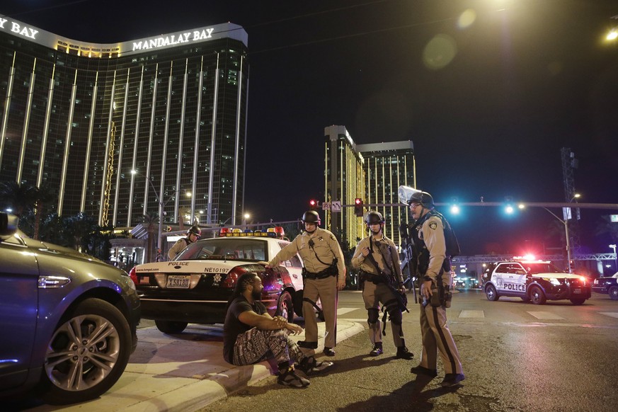 Police officers stand at the scene of a shooting near the Mandalay Bay resort and casino on the Las Vegas Strip, Sunday, Oct. 1, 2017, in Las Vegas. Multiple victims were being transported to hospital ...