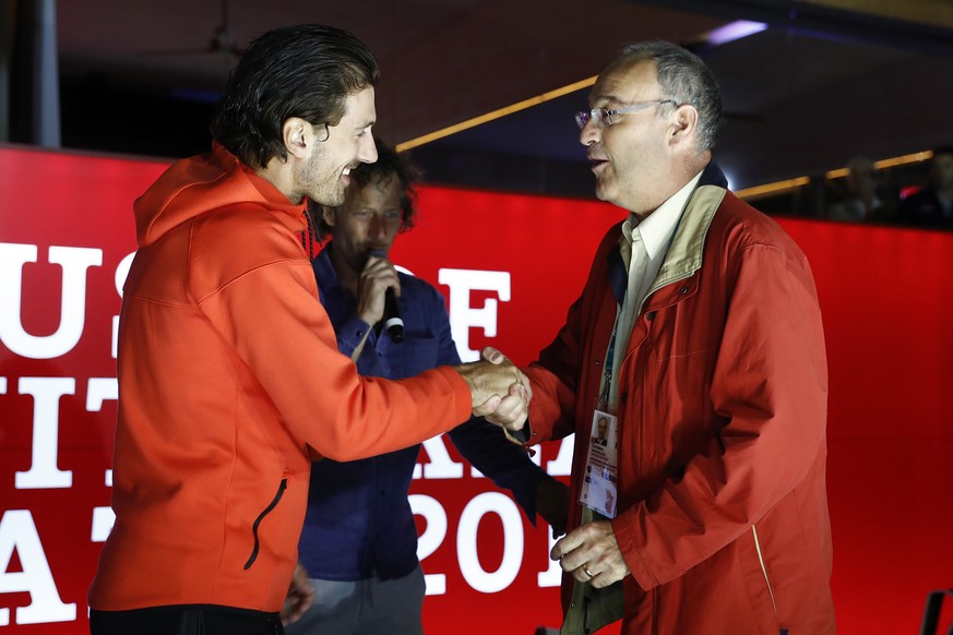 Gold medal winner Fabian Cancellara of Switzerland, left, and Swiss Sport Minister Guy Parmelin, right, shake hands in the House of Switzerland at the Rio 2016 Summer Olympics in Rio de Janeiro, Brazi ...