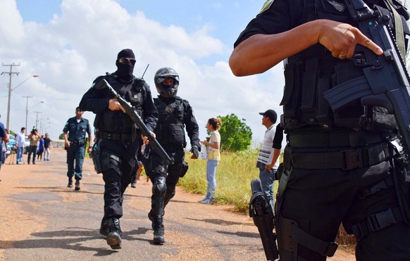 BRAZIL OUT - Heavily armed police officers walk outside the Agricultural Penitentiary of Monte Cristo, after dozens of inmates were killed, in Boa Vista, Roraima state, Brazil, Friday, Jan. 6, 2017. S ...