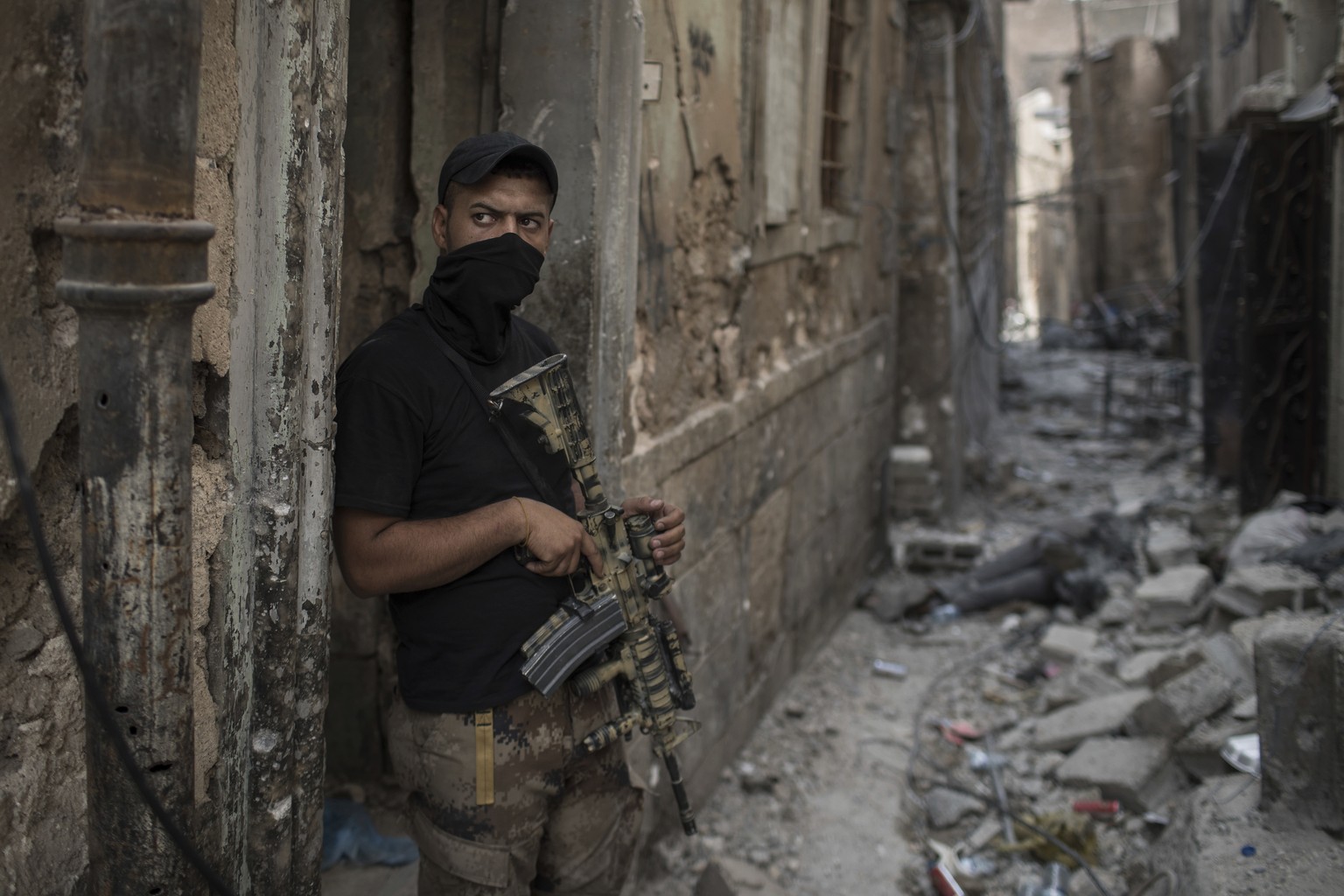 An Iraqi Special Forces soldier stands in position in an alley near the frontline as Iraqi forces continue their advance against Islamic State militants in the Old City of Mosul, Iraq, Friday, July 7, ...