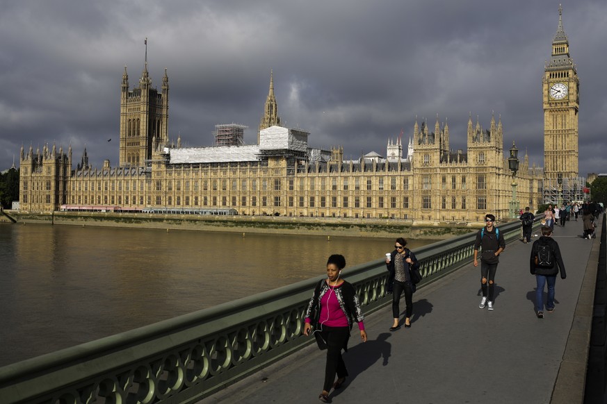 People cross Westminster Bridge in front of the Houses of Parliament the day after Britain&#039;s national elections on London, Friday, June 9, 2017. British Prime Minister Theresa May&#039;s gamble i ...
