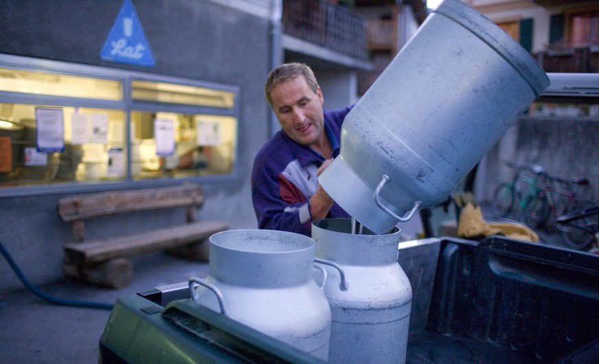 Ein Bauer leert vor der Molkerei in Sent im Engadin, Kanton Graubuenden, Schweiz, seine Milchkannen um, aufgenommen am 16. Oktober 2006. (KEYSTONE/Martin Ruetschi) === , ===
A farmer empties his milk ...