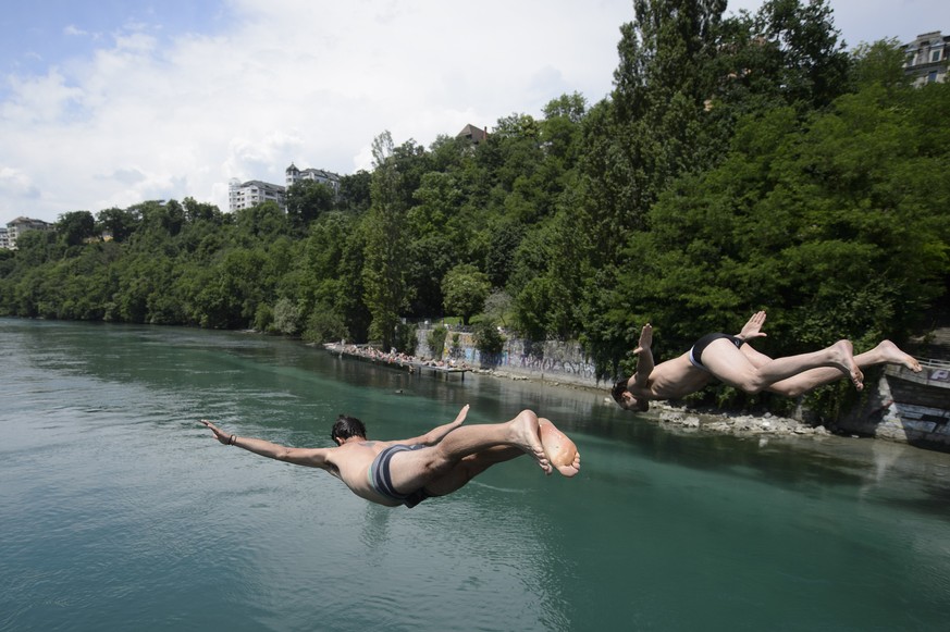 Deux personnes plongent depuis le Pont Sous-Terre dans le Rhone, ce dimanche 7 juin 2015 a Geneve. (KEYSTONE/Martial Trezzini)