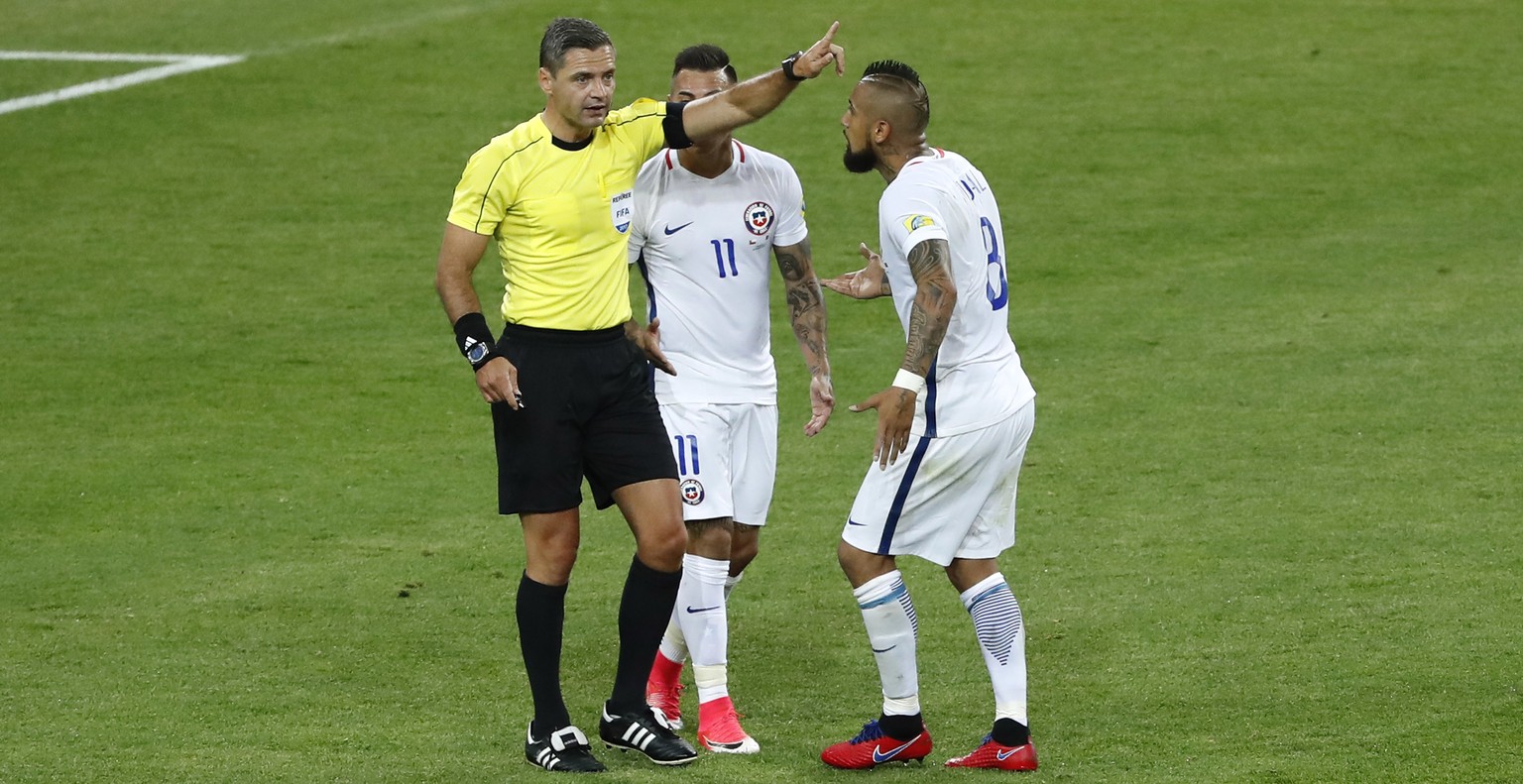 Chile&#039;s Arturo Vidal, right, and Eduardo Vargas argue with referee Demir Skomina during the Confederations Cup, Group B soccer match between Cameroon and Chile, at the Spartak Stadium in Moscow,  ...