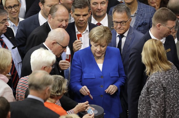 German Chancellor Angela Merkel casts her vote during a meeting of the German Federal Parliament, Bundestag, at the Reichstag building on the ballot of the marriage for everybody in Berlin, Germany, F ...
