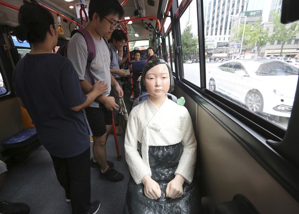 A comfort woman statue is placed on a chair of a bus to mark the 5th International Memorial Day for Comfort Women in Seoul, South Korea, Monday, Aug. 14, 2017. Comfort women are a euphemistic expressi ...