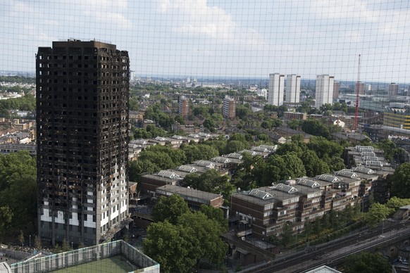 epa06035824 A general view of the remains of Grenfell Tower, a 24-storey apartment block in North Kensington, London, Britain, 18 June 2017. Search and Rescue efforts are continuing to sift through th ...