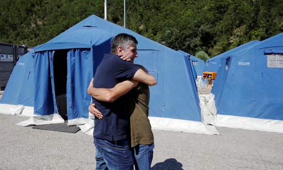 Two survivors hug at a tent camp set up as temporary shelter following an earthquake in Pescara del Tronto, central Italy, August 26, 2016. REUTERS/Max Rossi