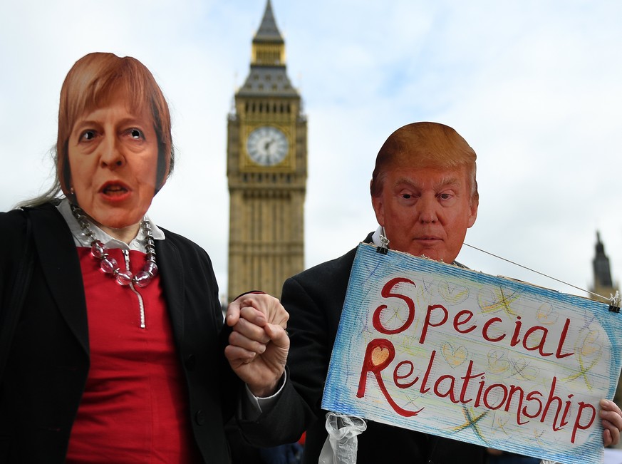 epa05805537 Protesters wearing masks depicting British Prime Minister Theresa May (L) and US President Donald J. Trump (R) and holding hands demonstrate against the proposed State visit to the UK of D ...